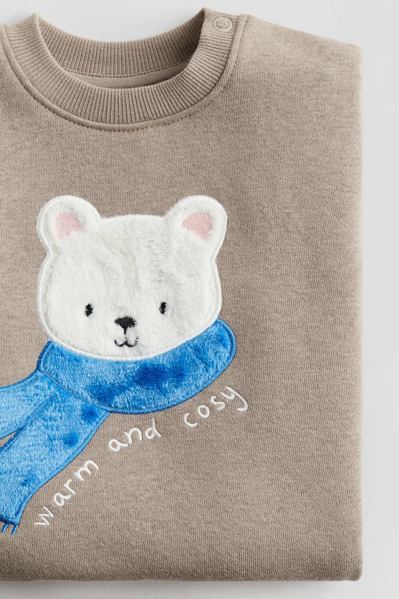 اتش اند ام بلوزة سميكة مزينة برسمة